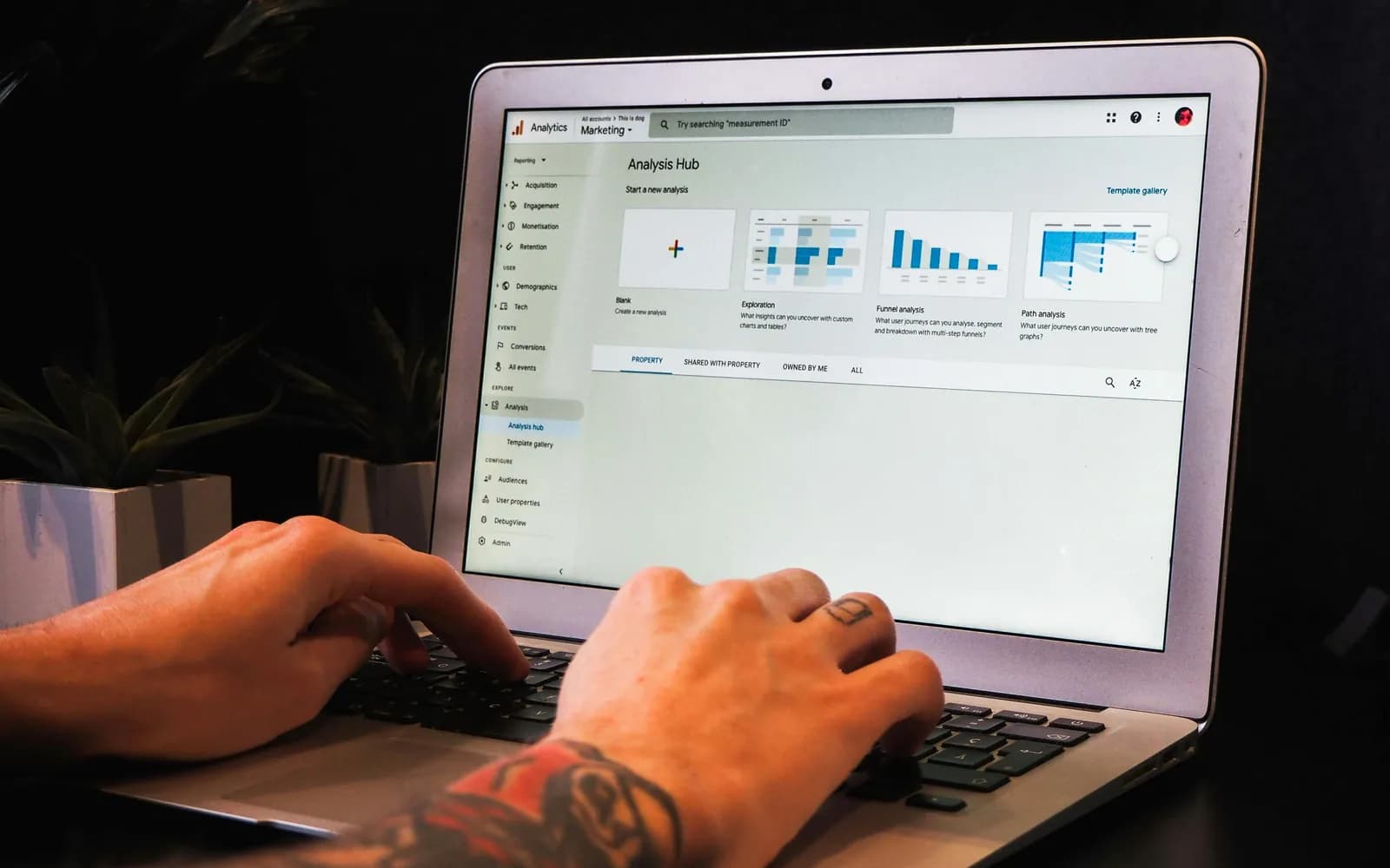 A person working in Google Analytics on a laptop.