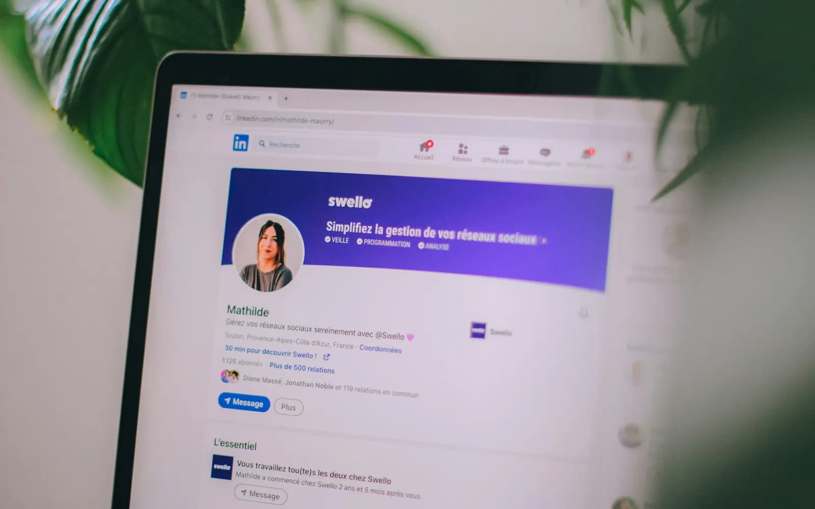 A laptop showing a LinkedIn profile page on a desk.