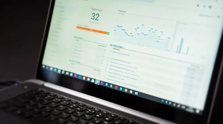 A laptop screen showing a real-time website analytics report with a pageviews chart and a list of top pages